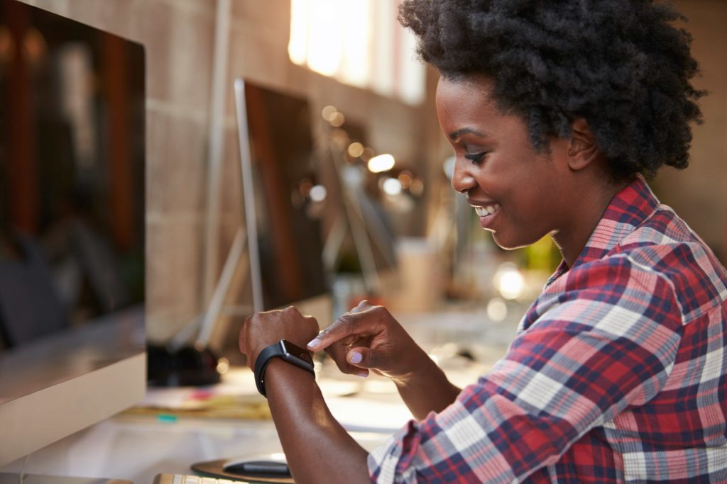 Woman using wearable smart watch at desk