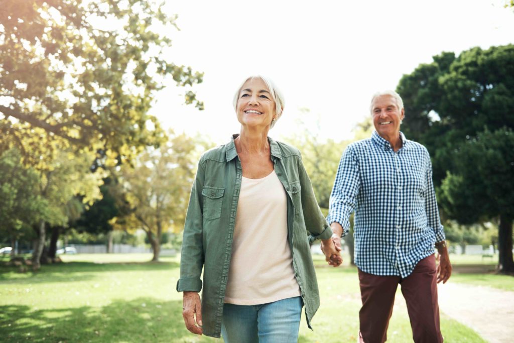 Happy senior couple enjoying walk in the park