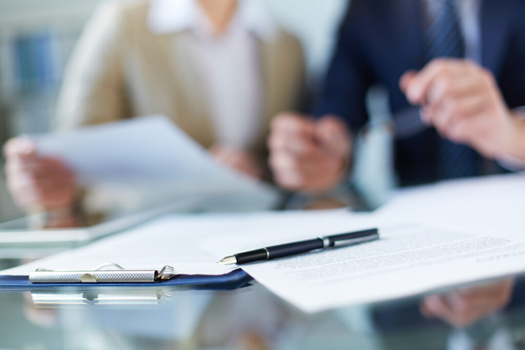 Healthcare leaders sign paperwork or letter.