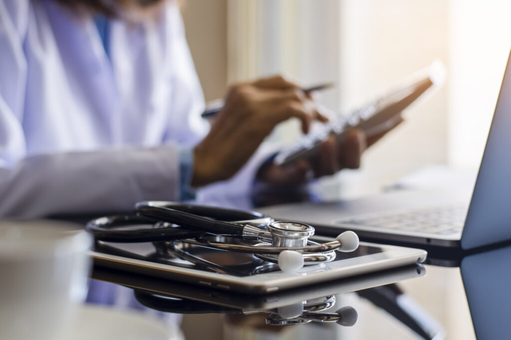 Doctor sets aside stethoscope and tablet to use calculator for revenue cycle purposes.