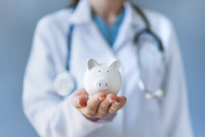 Doctor holding piggy bank to signify enhanced revenue cycle management.