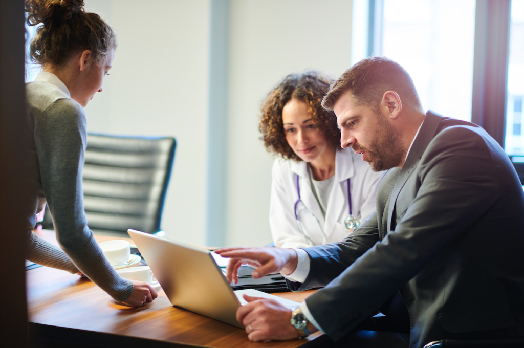 Physician enablement partner meets with doctor over coffee.