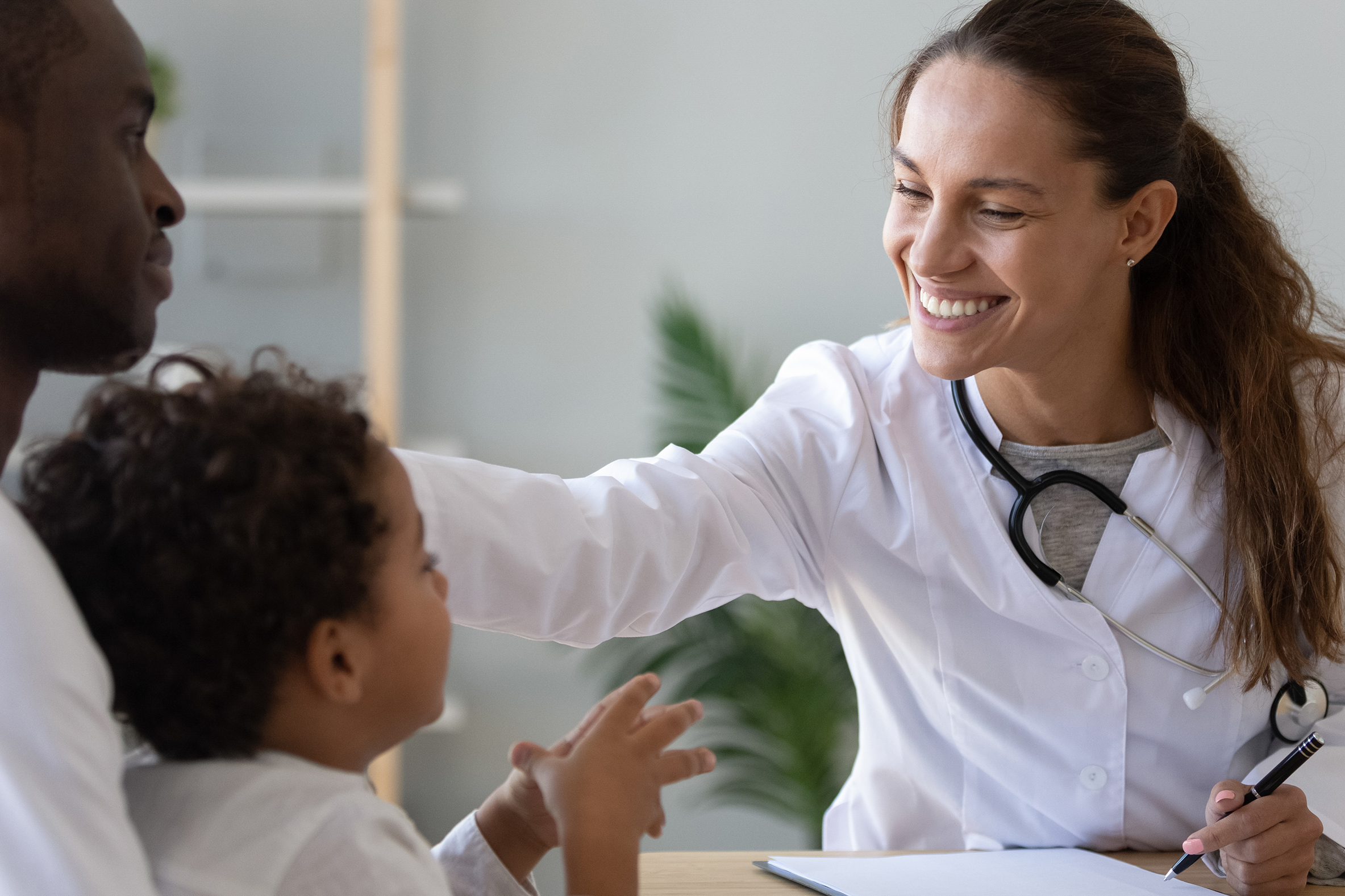 Independent pediatrician consulting child and caregiver.